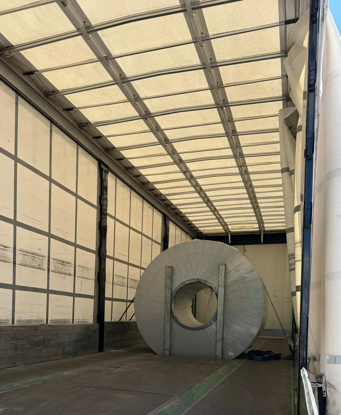 Bobina metálica asegurada dentro de un semirremolque de lona